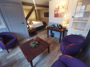 布隆克霍斯特赫伯格的古顿莱乌酒店的一间设有两把椅子、一张桌子和一张床的房间