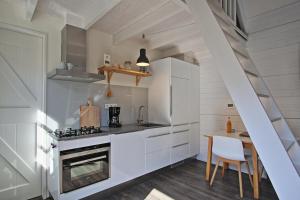 栋堡Vakantiehuisje Lijsterhofstraat 13 - Baddomburg的厨房配有白色橱柜和炉灶烤箱。