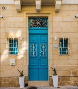 ŻabbarTa' Ġilard - Lovely Renovated Holiday Home的大楼内带2扇窗户的蓝色门