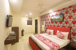 新德里Kelvish Hotel-Delhi Airport的一间卧室配有一张大床和红色床头板