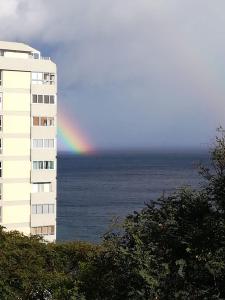 圣克鲁斯Tamariz Flat的一座建筑旁的海面上方的彩虹