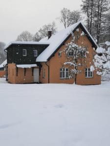 RudníkApartmány Rudník Bolkov的雪地里覆盖着的红色谷仓