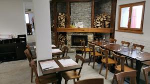 圣吕克Cabane Bella-Tola的一间带桌椅和壁炉的用餐室