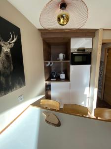 阿沃里亚兹Avoriaz le M1212的厨房配有白色冰箱,墙上挂着鹿的照片