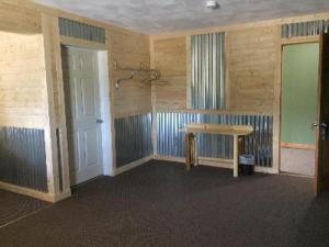 LewistownBig Horse Inn and Suites的一间空房间,配有桌子和淋浴