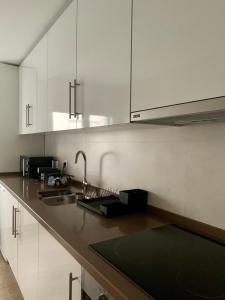 科维良Art'Estrela的厨房配有白色橱柜和水槽