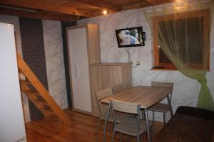 ŁokcioweOaza Spokoju的一间设有桌子和墙上电视的用餐室