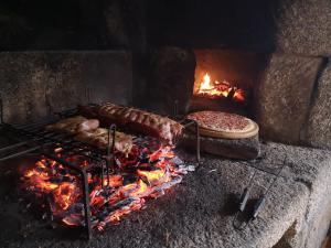 贡多马尔Hogar Gallán的烤架,烤一些肉和烤火烤比萨饼