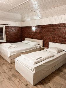 利沃夫利沃夫旅馆的带三张床和砖墙的房间