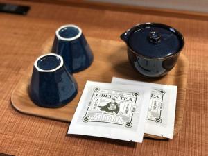 奈良Hotel OBANA的三个蓝色花瓶坐在桌子上,边看书边