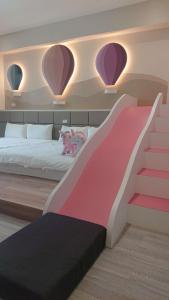 安平区胖蝸牛親子民宿的卧室配有粉色和白色的床和楼梯。