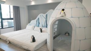 安平区胖蝸牛親子民宿的儿童卧室配有一张带企鹅的冰屋床