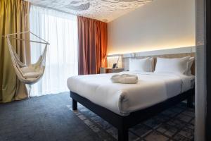 阿拉木图ibis Almaty Jetisu的酒店客房配有一张床和吊床