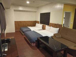 Wenquan九族飯店 臺東縣旅館004號的酒店客房,设有两张床和一张沙发