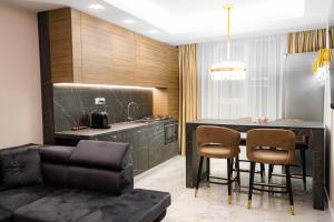 苏恰瓦Deluxe Aparthotel MARWELL RESIDENCE的厨房以及带黑色桌椅的用餐室。