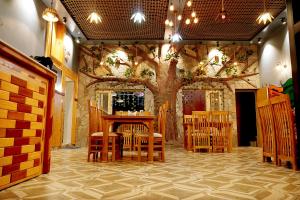 拉尼凯特HOTEL DEV CHHAYA的一间设有椅子和桌子的树的房间
