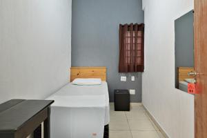 里贝朗普雷托HOTEL & HOSTEL RIBEIRAo的小房间设有一张床和一张桌子