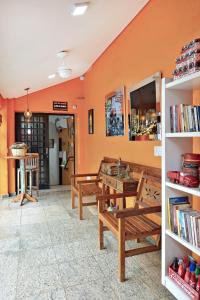 里贝朗普雷托HOTEL & HOSTEL RIBEIRAo的一间设有两张长椅和一张桌子的房间,还有书籍