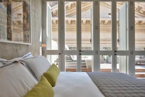 瓦莱塔Casa Ellul - Small Luxury Hotels of the World的卧室配有白色的床和大窗户