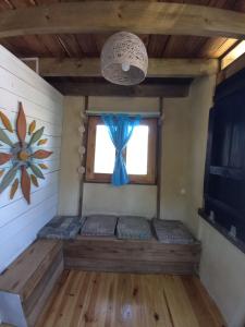 拉埃斯梅拉达Flor de Vida Geocabañas - Tiny的一间设有蓝色枕头的窗户的客房