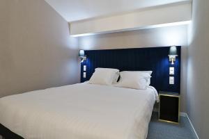 拉蒂尔比耶Hôtel Napoléon的一间卧室配有一张白色大床和蓝色床头板