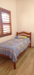弗雷谢拉斯Casa Tropicana的一间卧室配有一张带蓝色棉被的床和窗户。