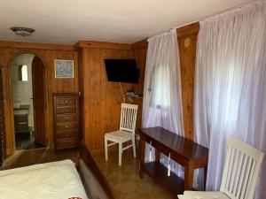 贝尼萨Bonito apartamento villa Joya的一间卧室配有一张桌子、一张床、一张书桌和窗帘