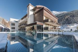 索尔登伯格兰设计及康体酒店的一座在雪中设有游泳池的建筑