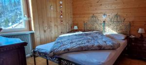 泰塞罗CASA PAMPEAGO - Sulle piste da sci del Latemar的卧室配有木墙内的一张床
