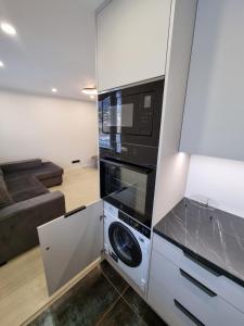 派尔努Tammsaare Luxury Apartment的厨房配有微波炉、洗衣机和烘干机
