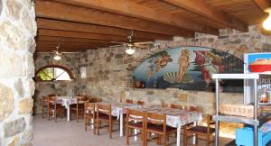莱夫基米ANEMOMYLOS Lefkimmi LUXUS SUITES-BOUTIQUE HOTEL & POOL的石墙内带桌椅的餐厅