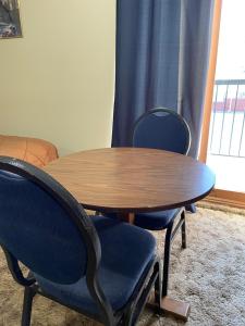 史密瑟斯山景汽车旅馆的一张木桌、两把椅子、一张桌子和一个窗口