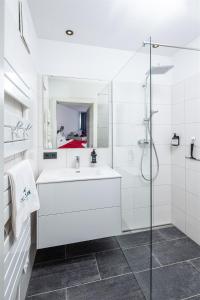 滨湖采尔Falcon Suites Zell am See的白色的浴室设有水槽和淋浴。