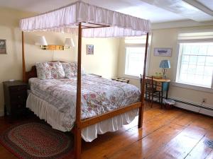 ChesterFranklyn Farm Inn的卧室配有一张华盖床,铺有木地板