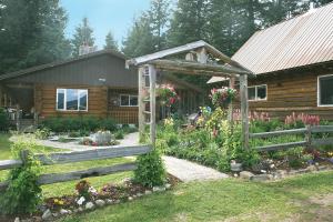 AtholCedar Mountain Farm Bed and Breakfast LLC的一座带围栏和鲜花的木屋