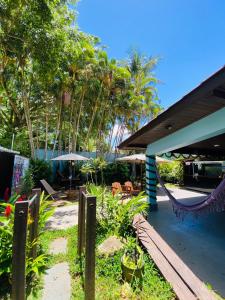 瓜鲁雅Tombo Beach Hostel & Pousada的门廊配有吊床、椅子和树木