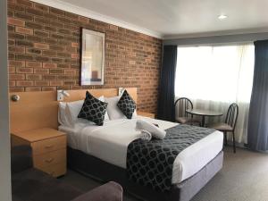 滕特菲尔德君布克汽车旅馆的一间卧室设有一张床和砖墙
