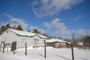 远轻町Tarochan House的雪中带栅栏的白色房子