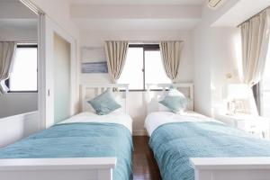 大阪Bloom Nagahori 904的白色客房的两张床,设有窗户
