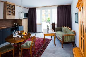 因特拉肯Carlton-Europe Vintage Adults Hotel的厨房以及带桌椅的起居室。