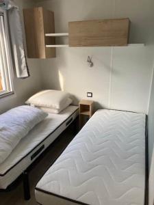 基伯龙Vue Mer的一间卧室设有两张床和窗户。