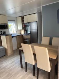基伯龙Vue Mer的厨房配有木桌和白色椅子