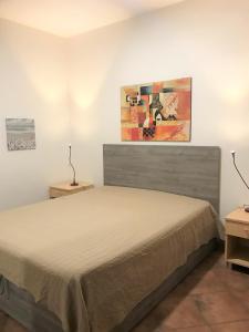 圣维托罗卡波Case Montalbano的卧室配有一张床,墙上挂有绘画作品