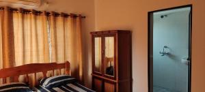 卡兰古特Esha Apartment的一间卧室配有一张床、镜子和窗户