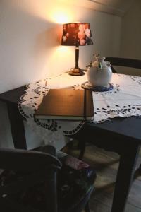 GramsbergenB&B t'Brocantje的一张桌子,上面有台灯和花瓶