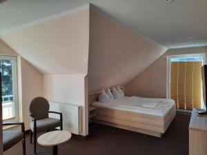 科尔平塞Hotel Karl's Burg的卧室配有床、椅子和窗户。