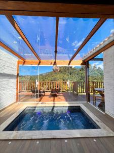 蒙特韦尔迪Estalagem da Montanha的一座带大玻璃窗的房屋内的游泳池