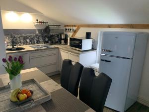 霍佩加尔滕FEWO Hoppegarten的厨房配有桌子和白色冰箱。