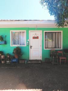 皮奇勒姆Los Rukos Cabanas (Bungalows)的绿色的房子,有白色的门和窗户