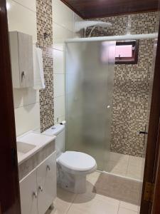佩尼亚Chalés Vô João的一间带卫生间和玻璃淋浴间的浴室